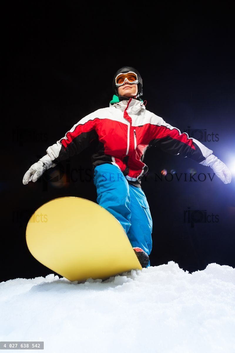 Young snowboarder wearing ski mask ready to slide