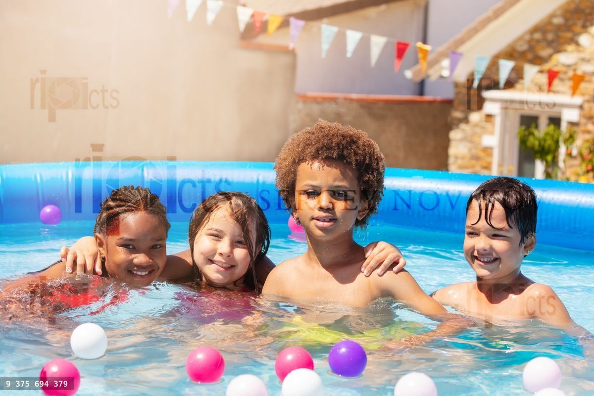 Four happy children hug sit smile in swim pool