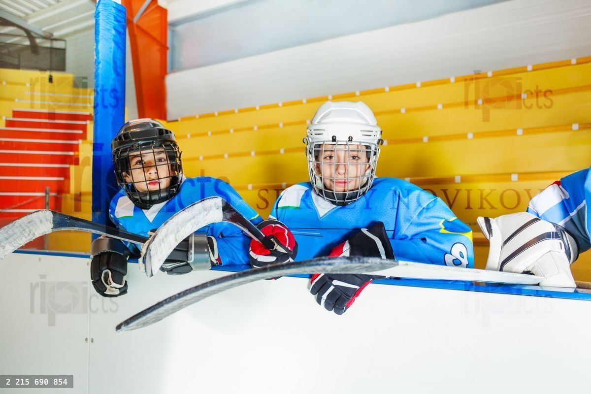 Young hockey players sitting on bench at stadium