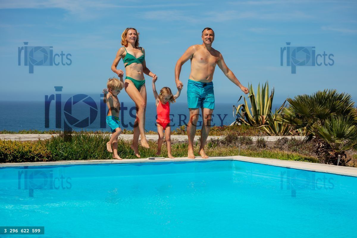 Young parents with two kids have fun on pool resort party
