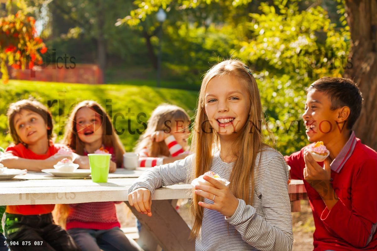 Heureux groupe d'enfants assis à une table en bois