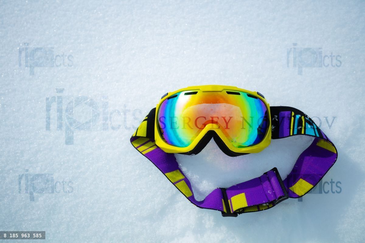Yellow ski mask in snow from above alpine vacation concept