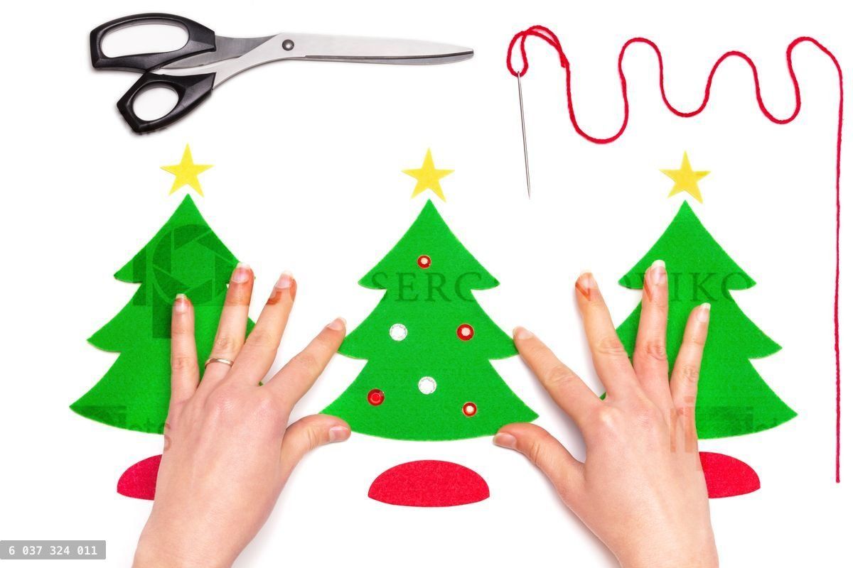 Woman decorating paper Christmas tree with sequins