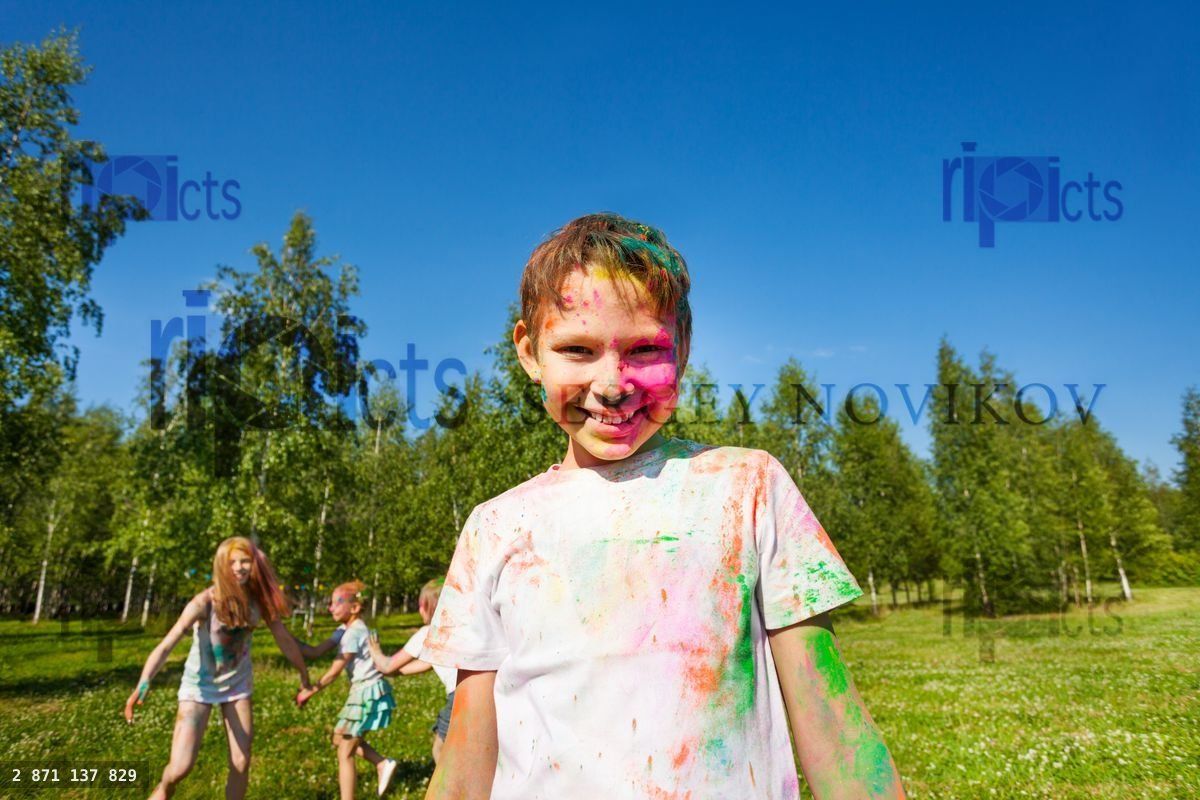 Happy boy painted in colors of Holi festival