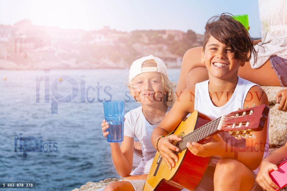 Young musician plays guitar at outing with friends