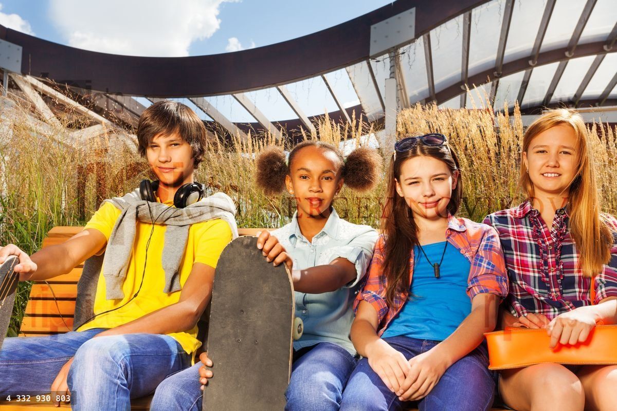 Boy and three girls sit on wooden bench together