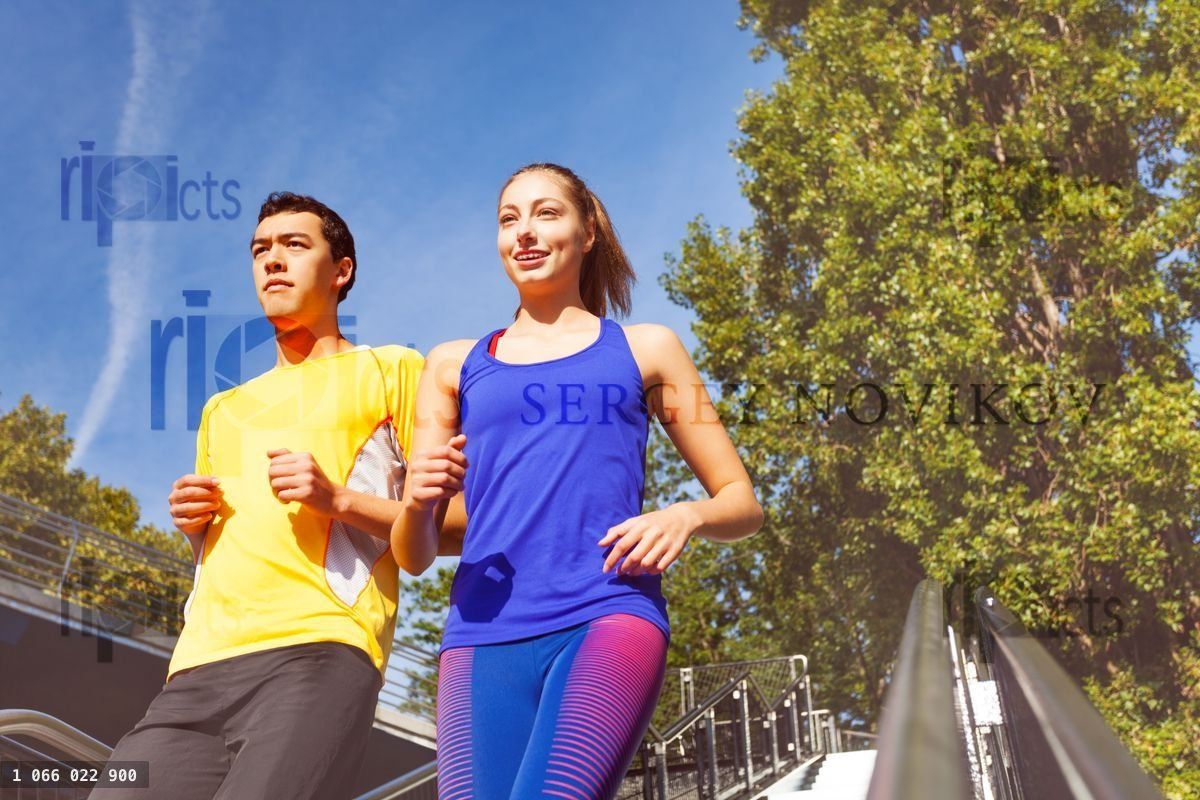 Young couple running downstairs on city stairs
