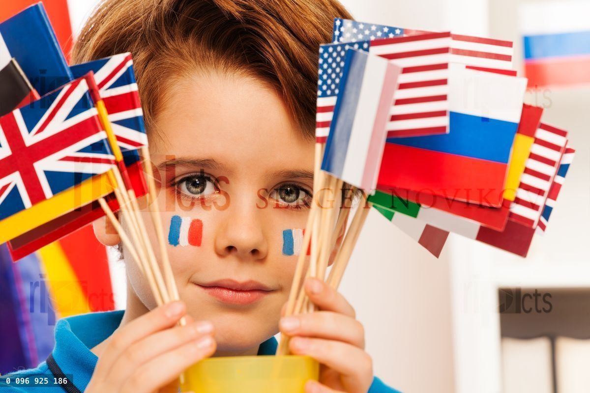 French boy with flag on cheeks hide behind banners