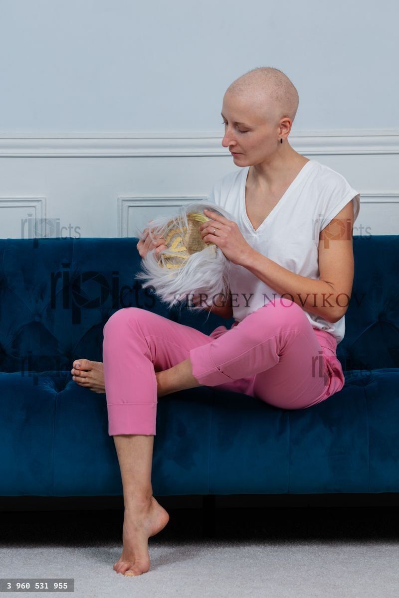 Woman with chemotherapy side effects sit and put her wig on