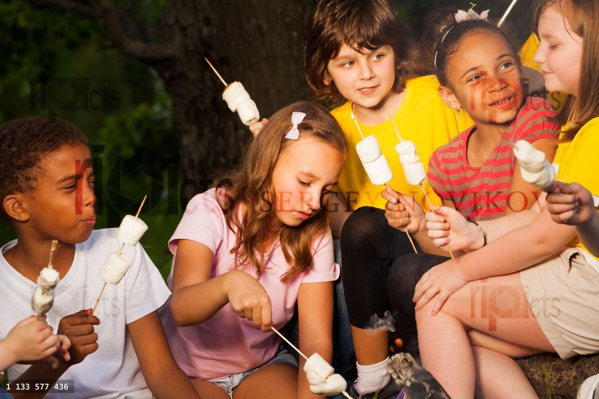 Enfants avec un dessert au feu de camp pendant un campement