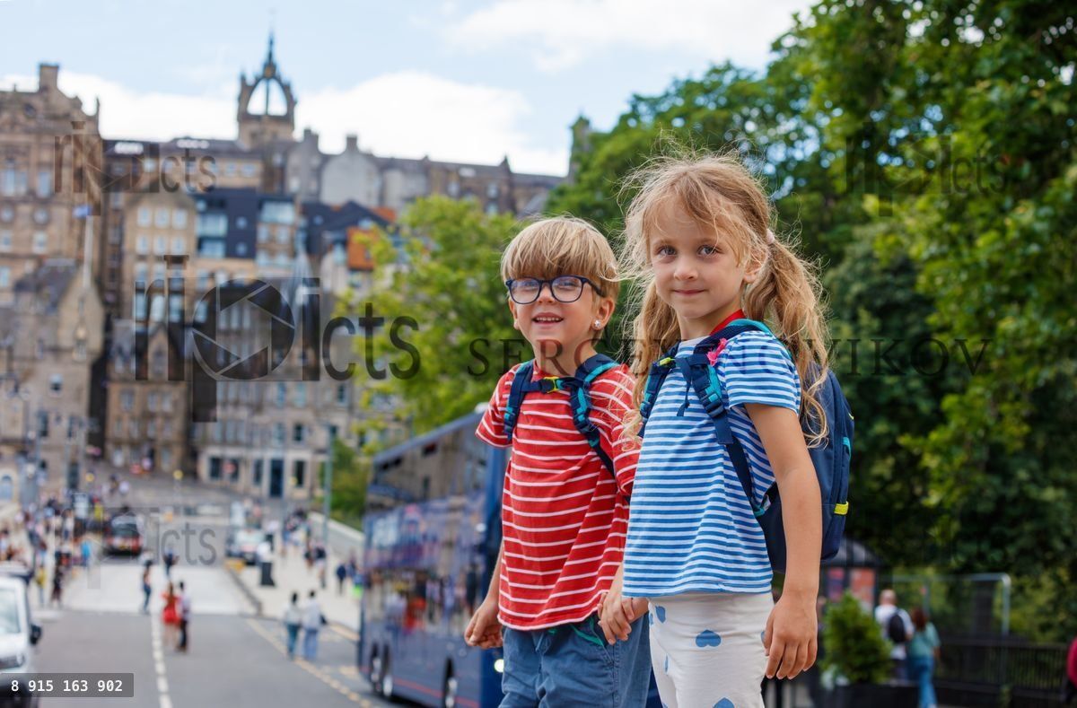 Des enfants avec des sacs à dos se tiennent dans une rue d'Édimbourg, en Écosse