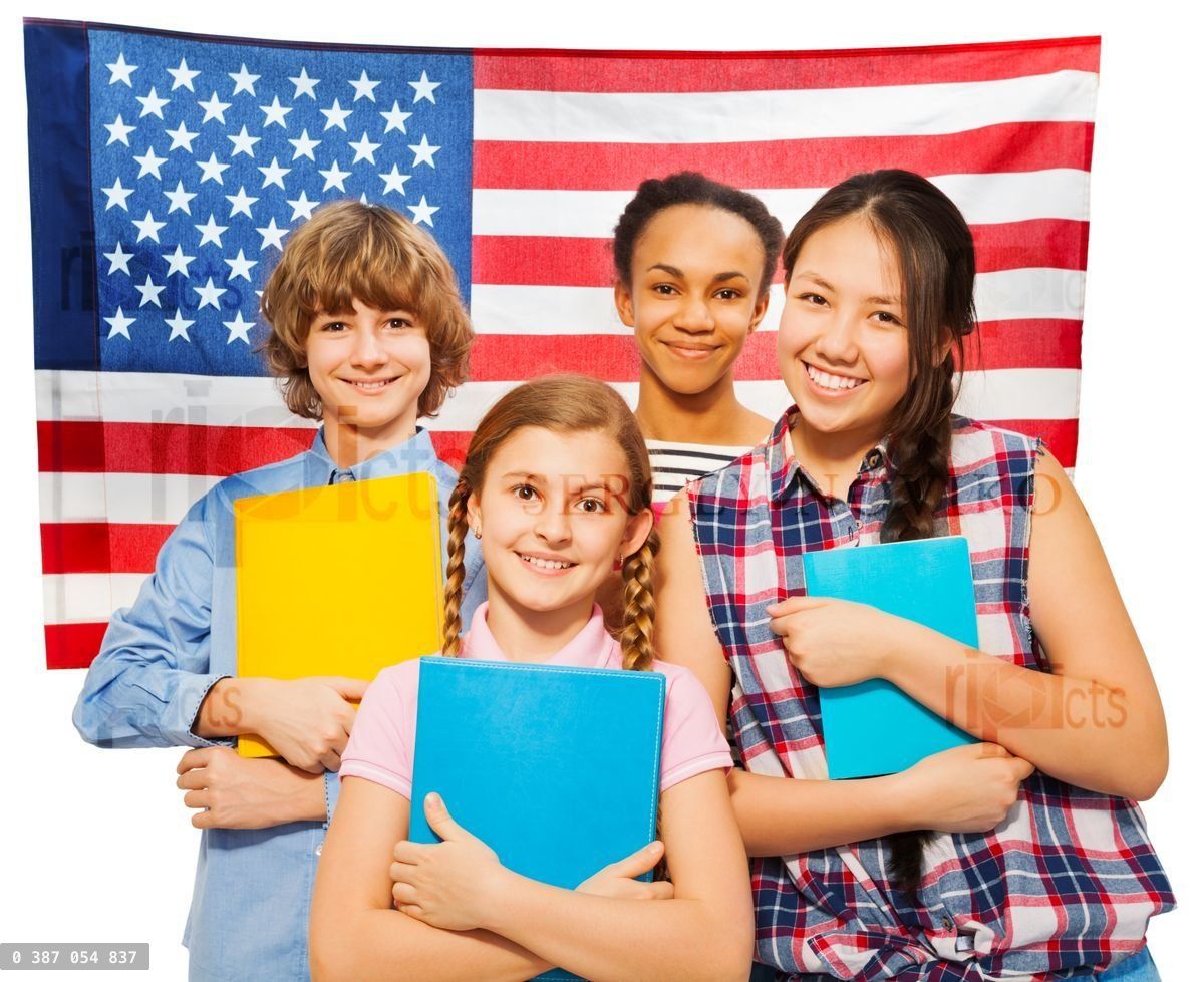 Four happy students standing against American flag