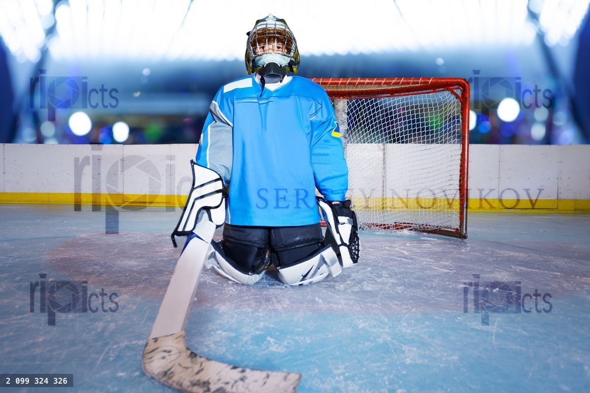 Young ice hockey goalie protecting the net