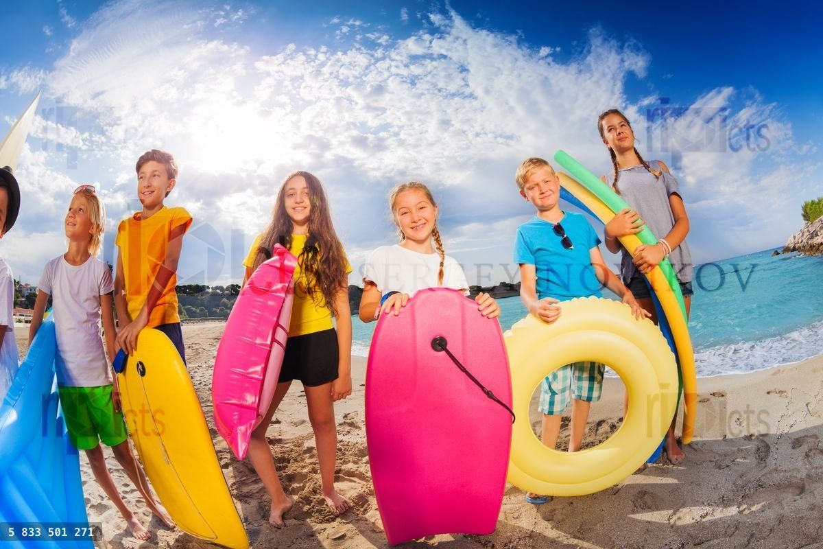 Group of kids in seashore with swimming equipment