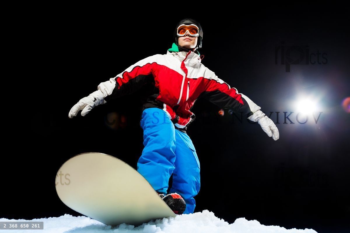 Young snowboarder wearing ski mask ready to slide