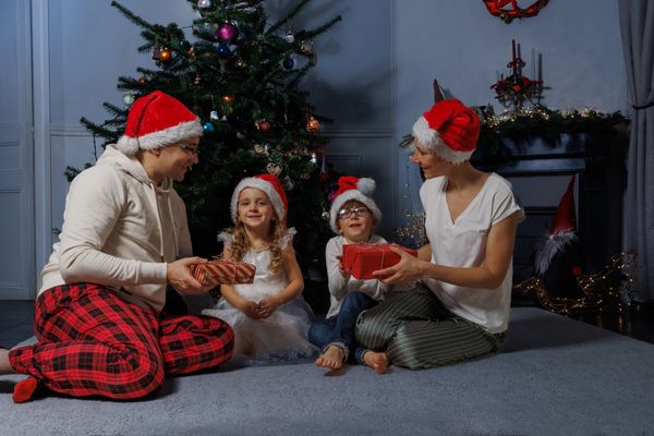 family enjoys a holiday moment by the decorated tree exchange p