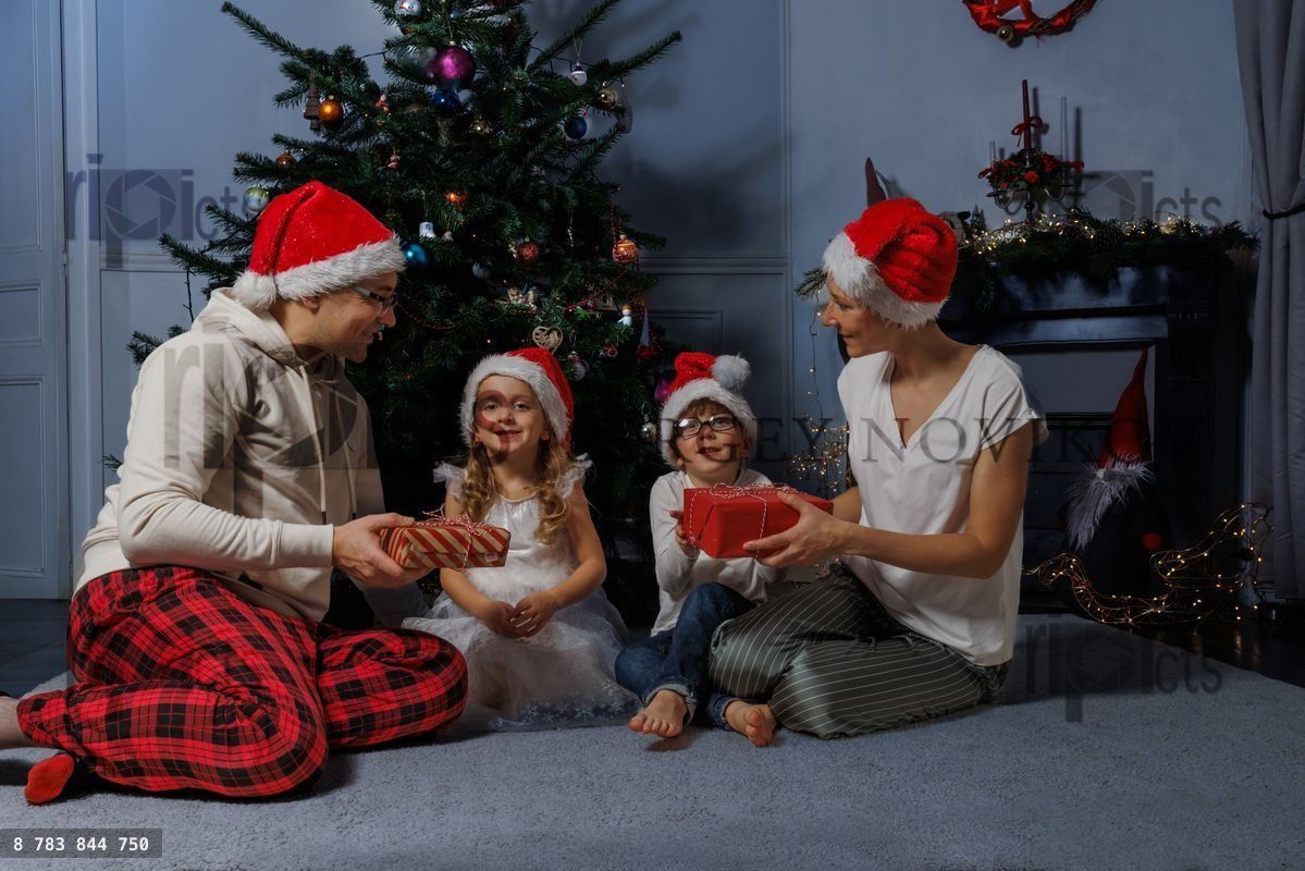 family enjoys a holiday moment by the decorated tree exchange p
