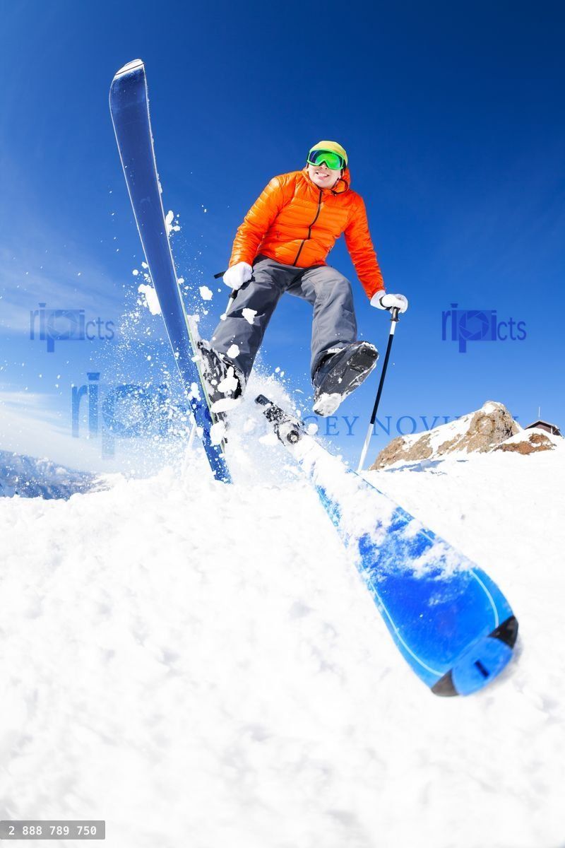 Young man in a jump while skiing view from below