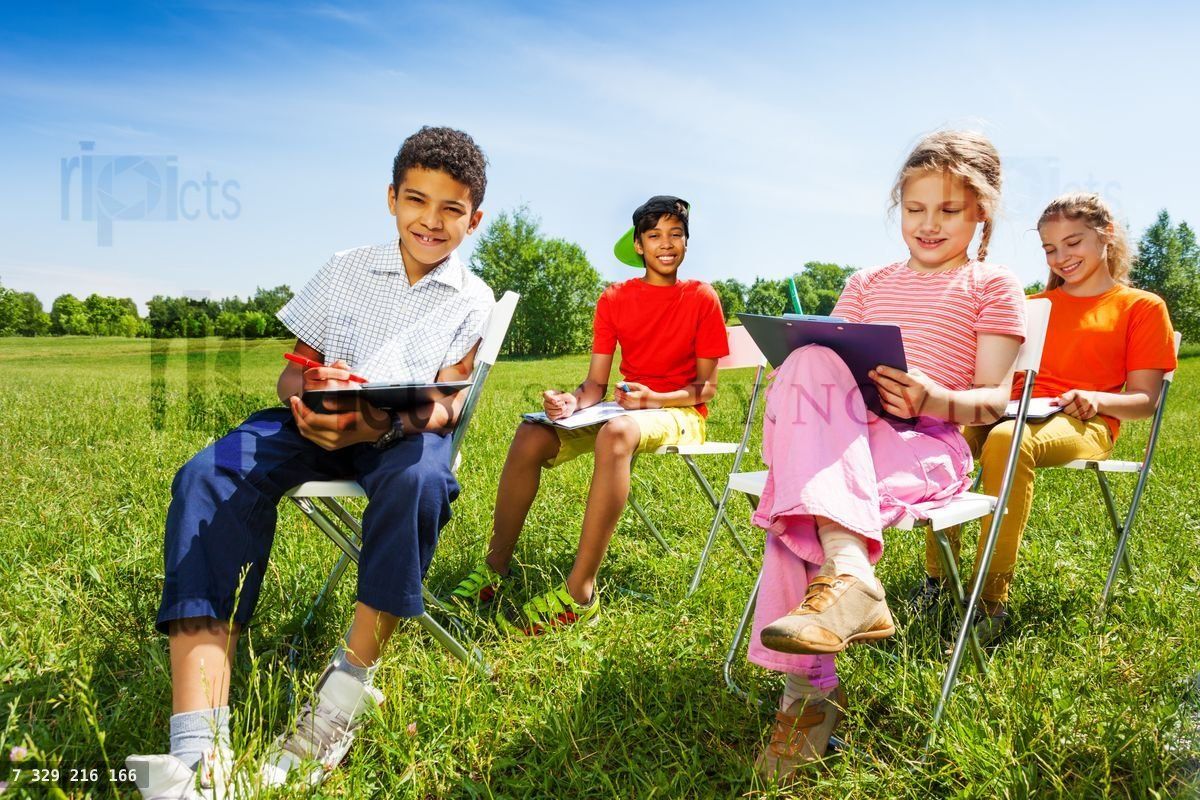 Funny kids hold sketch boards and sit outside