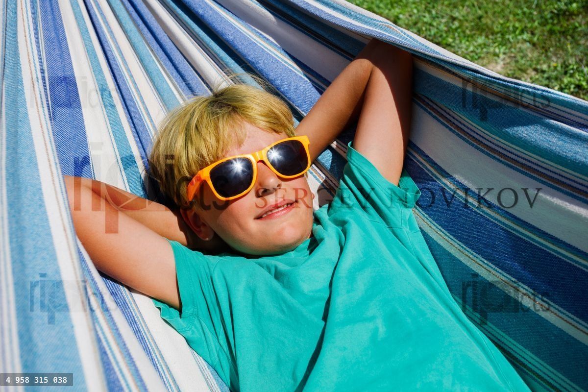 Boy with orange sunglasses lay in hammock close portrait