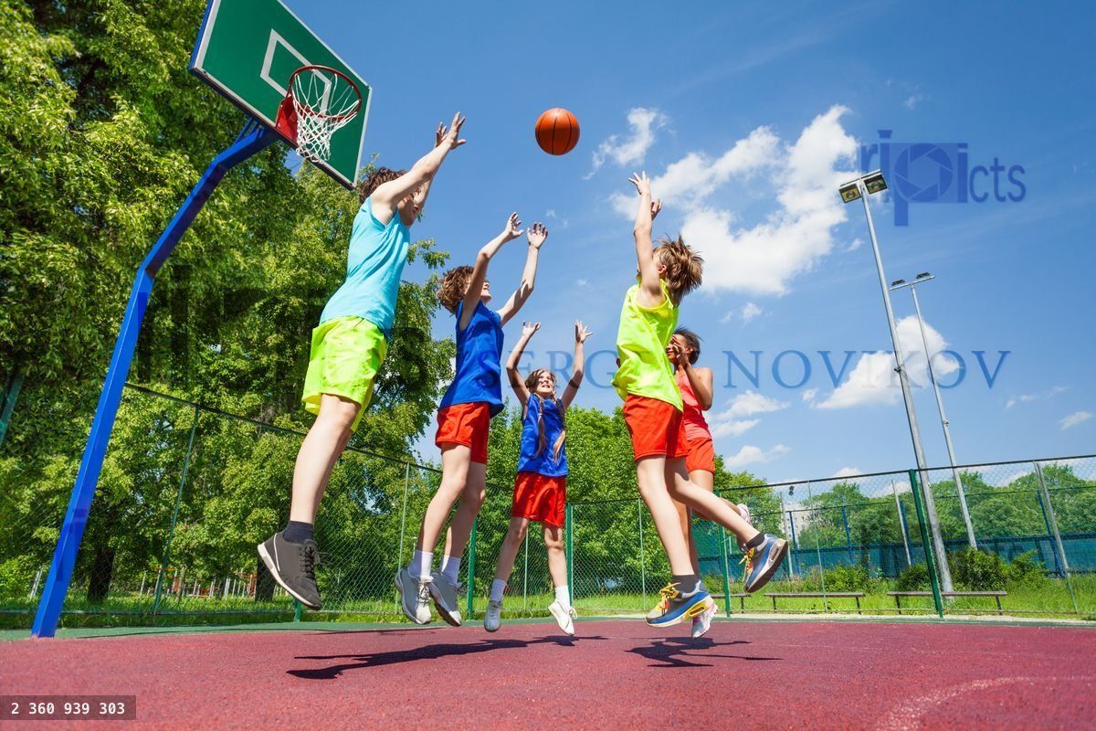 Children jump for flying ball during basketball