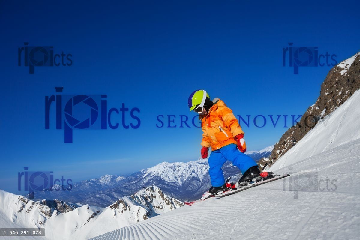 Brave small boy skiing alone on mountain slope