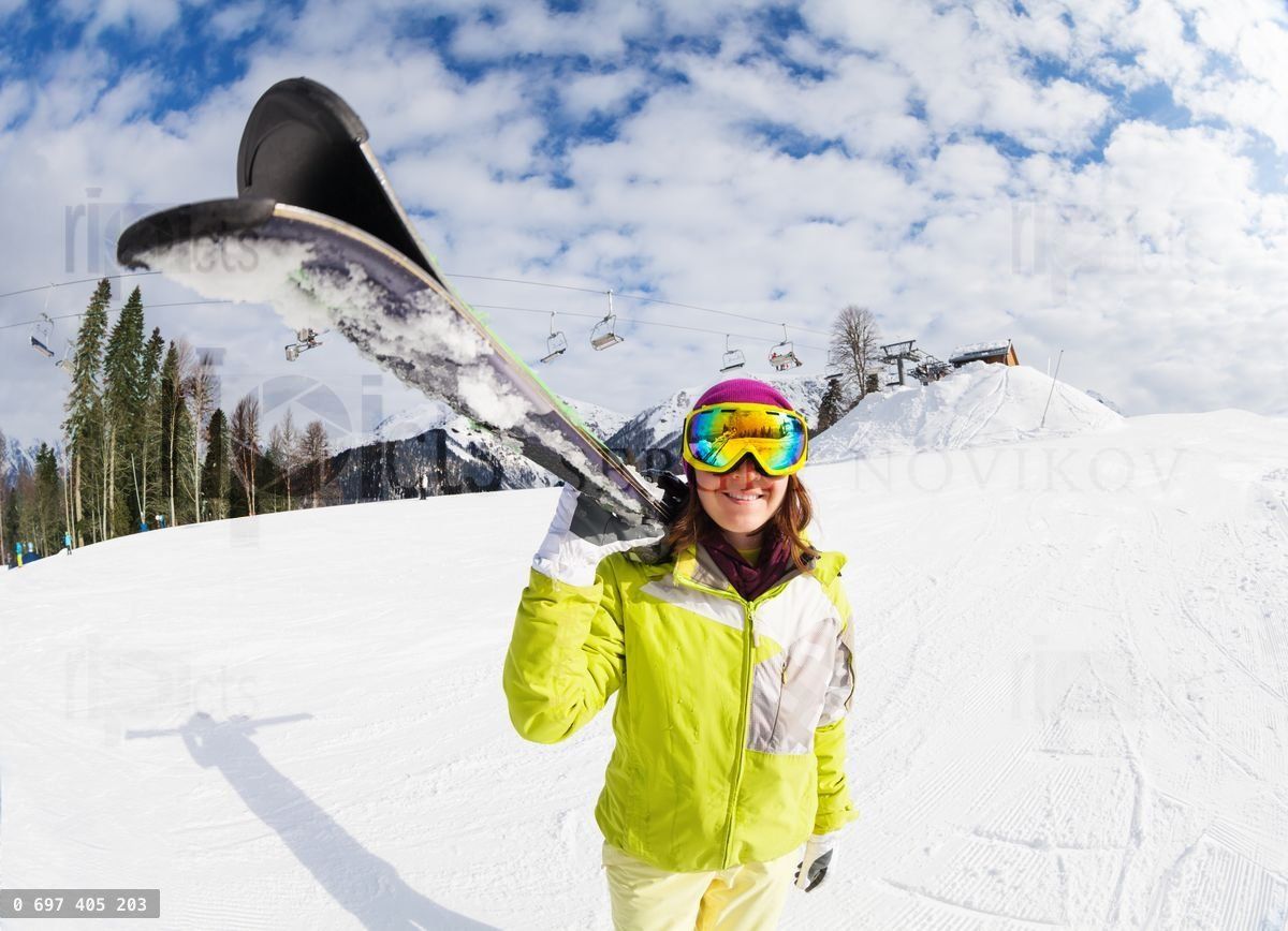 Young woman carry mountain ski on winter resort