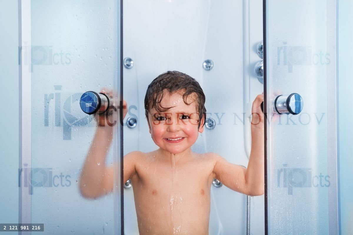 Happy boy in the shower cabin wet and smiling