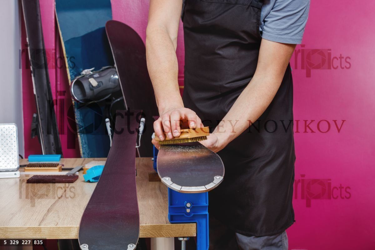 Hands of ski workshop professional brushing equipment