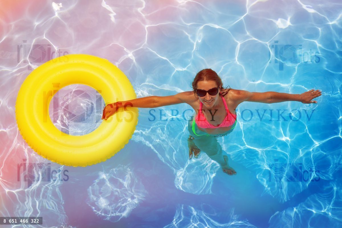 Woman in the swimming pool with yellow rubber ring