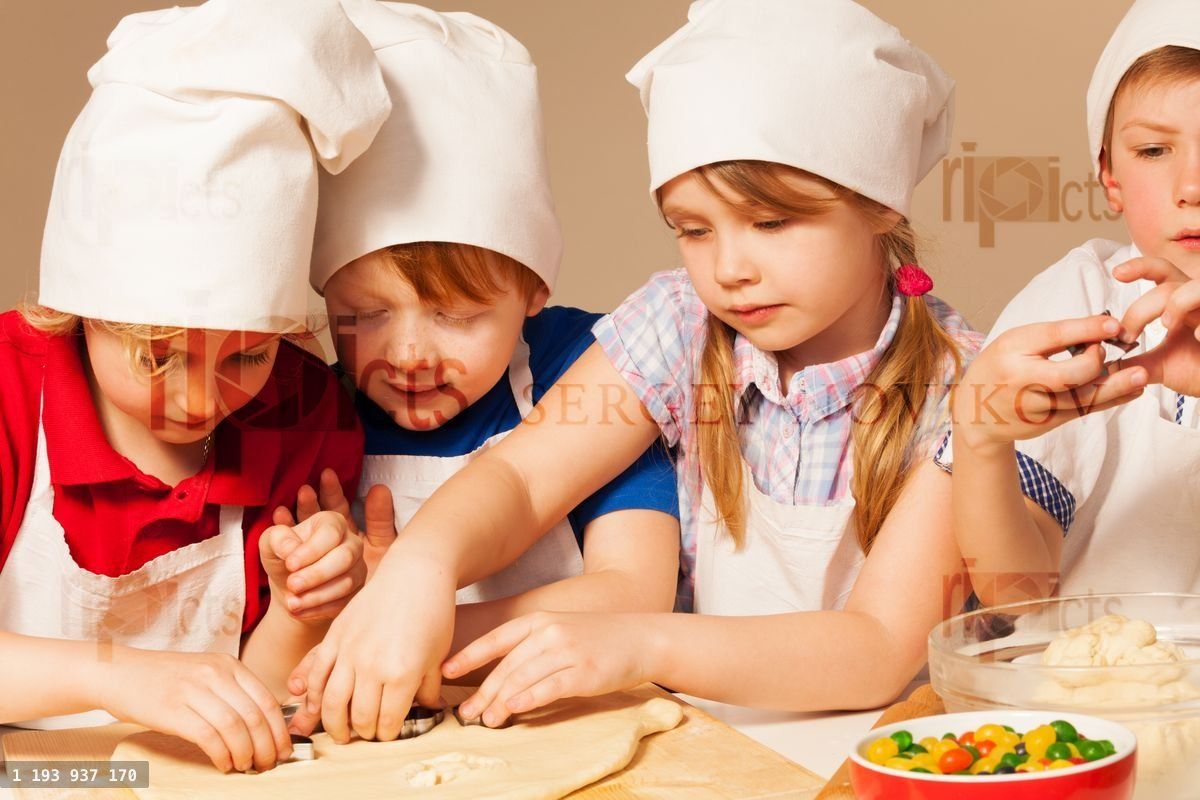 Four young chefs having fun making homemade cookie