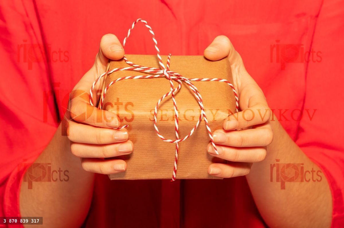 Woman's hands giving Christmas gift with lace bow