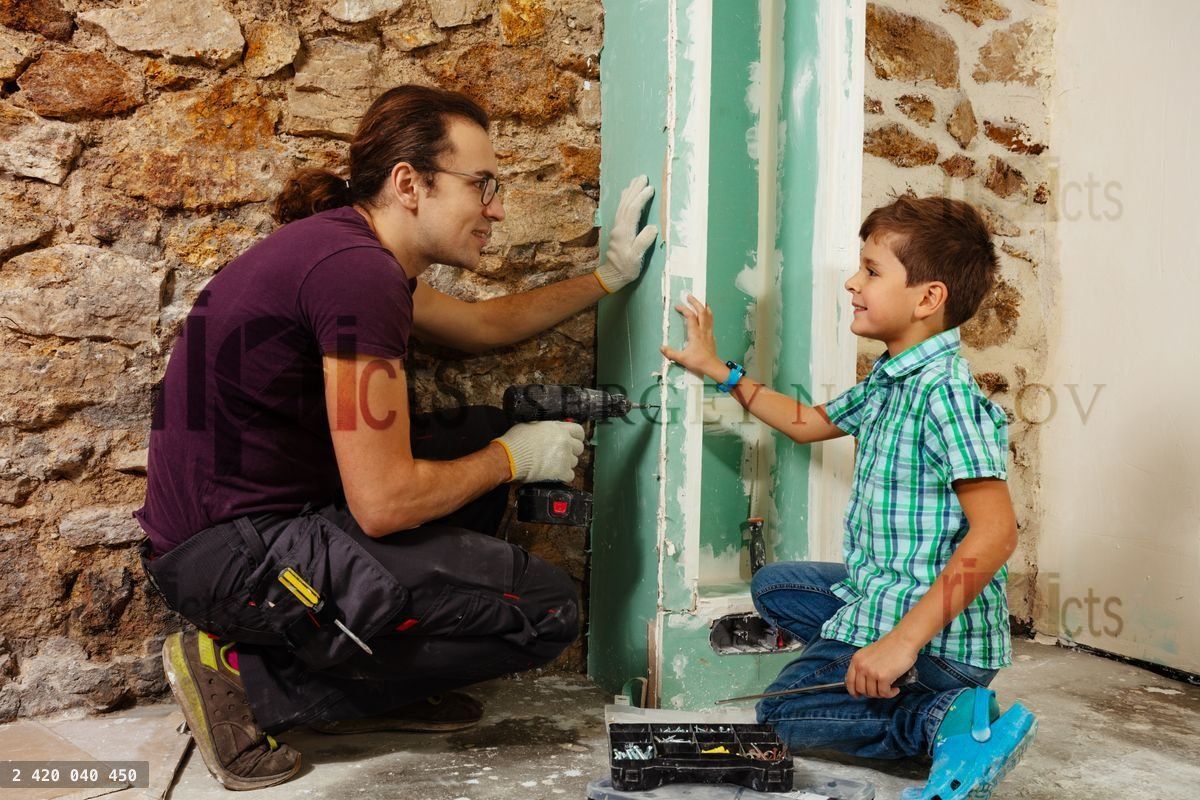 Young father teaches his boy how to use screwdriver
