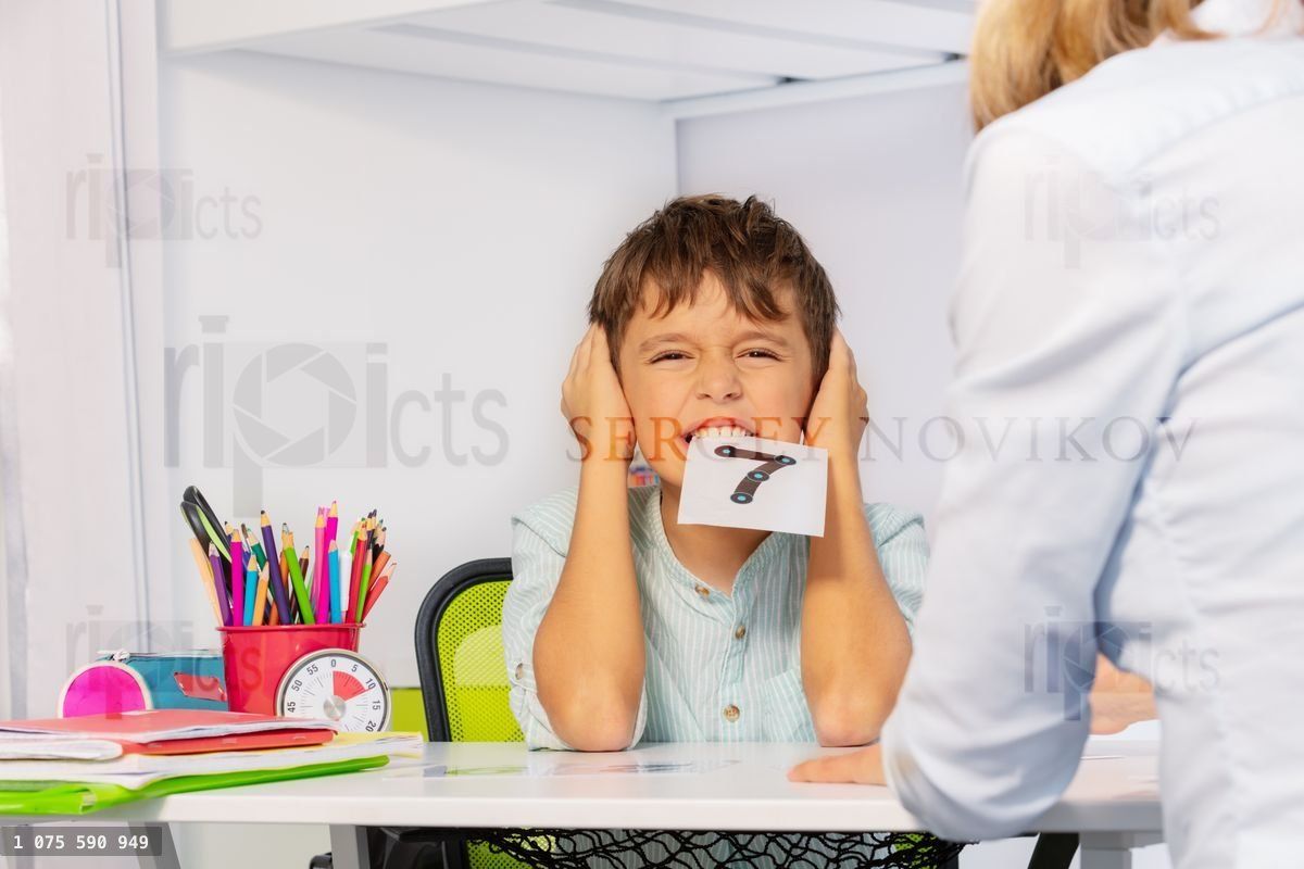 Woman teach boy with autism numbers at the table