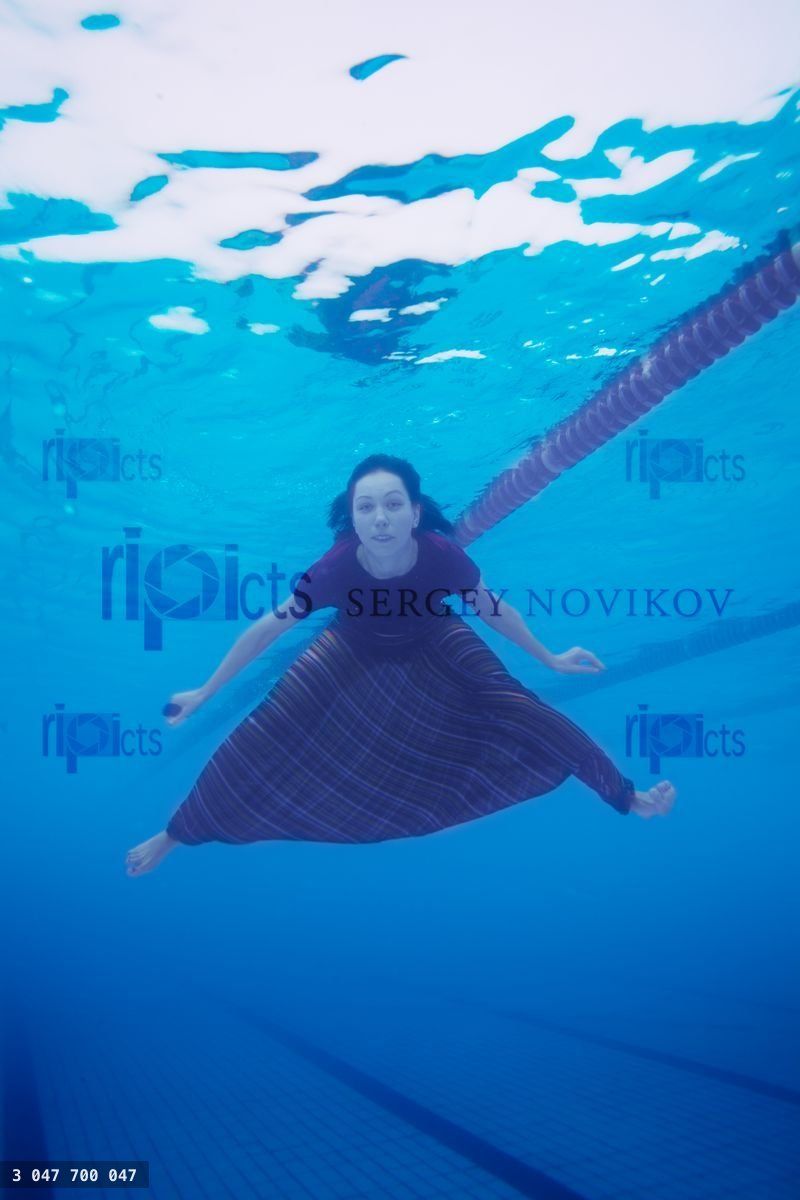 Woman swimming in the pool in clothes
