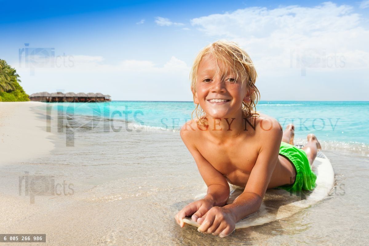 Happy boy on surfboard near the sea