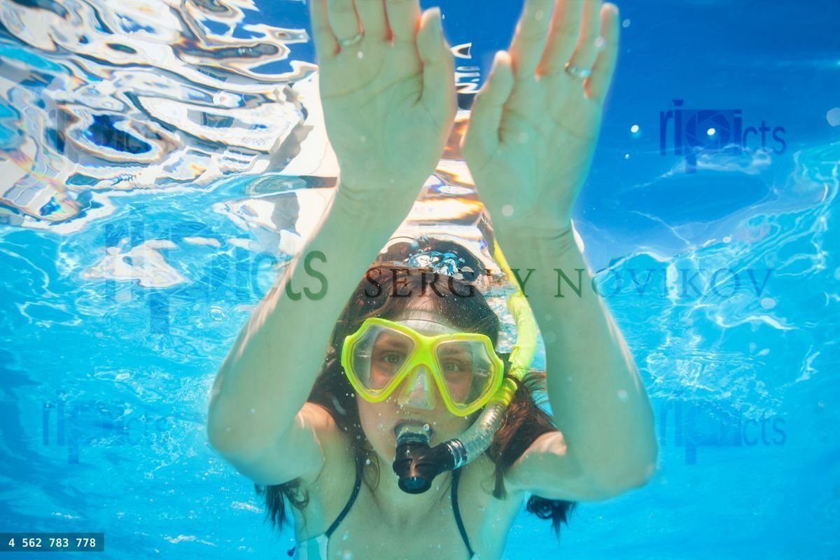 Woman wears snorkeling mask swimming underwater