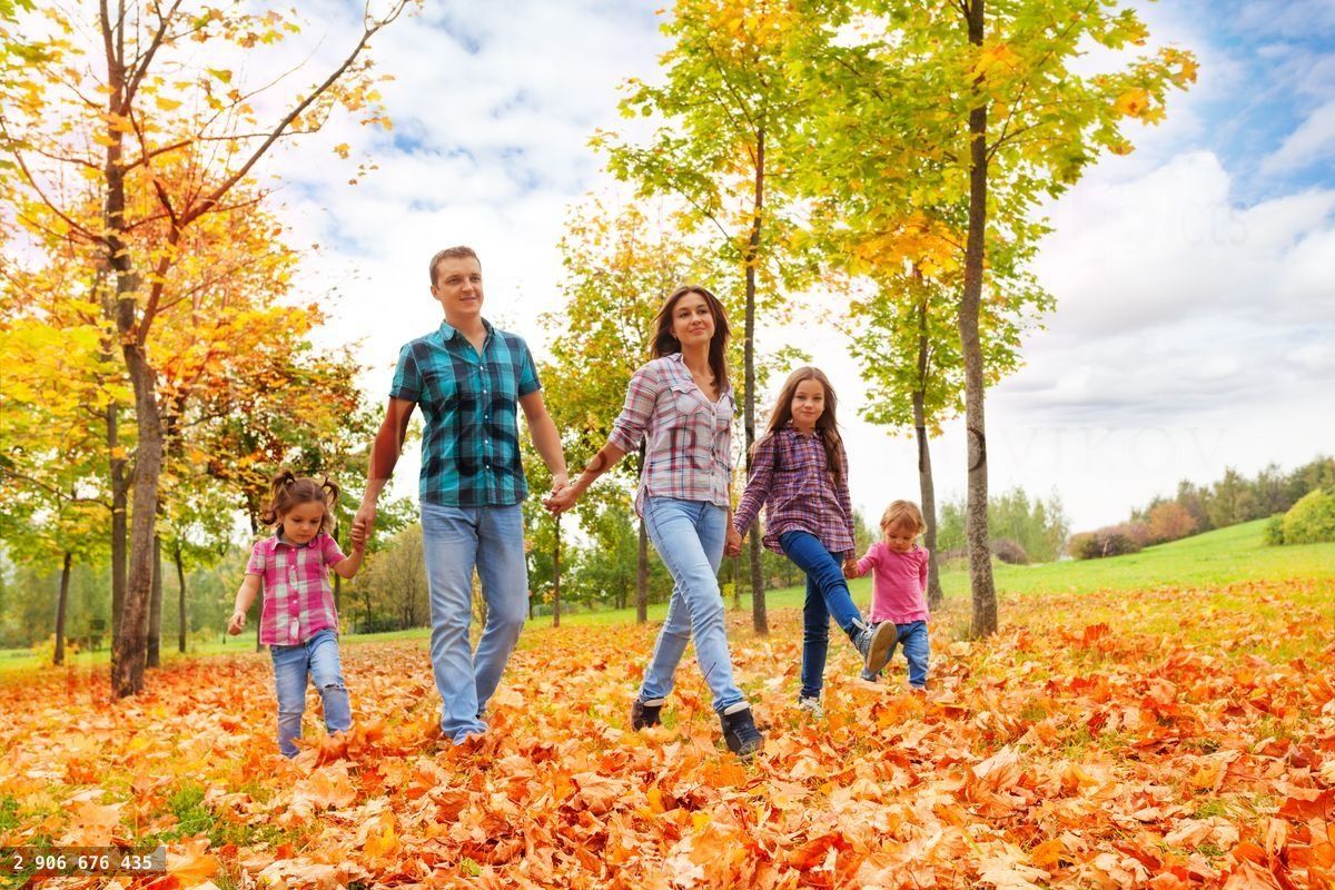 Famille heureuse avec trois enfants qui marchent en tenant la main