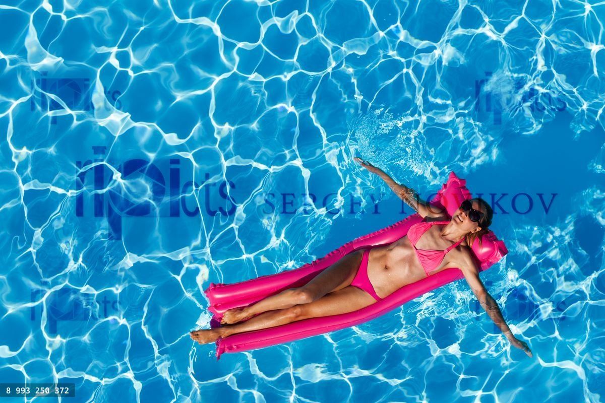 Woman floating on air mattress in swimming pool
