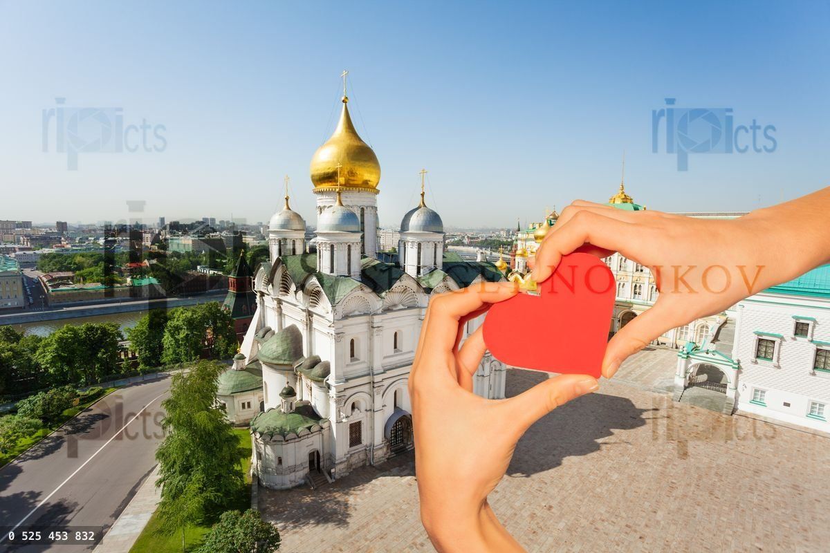Hand hold red heart over churches, Moscow Kremlin