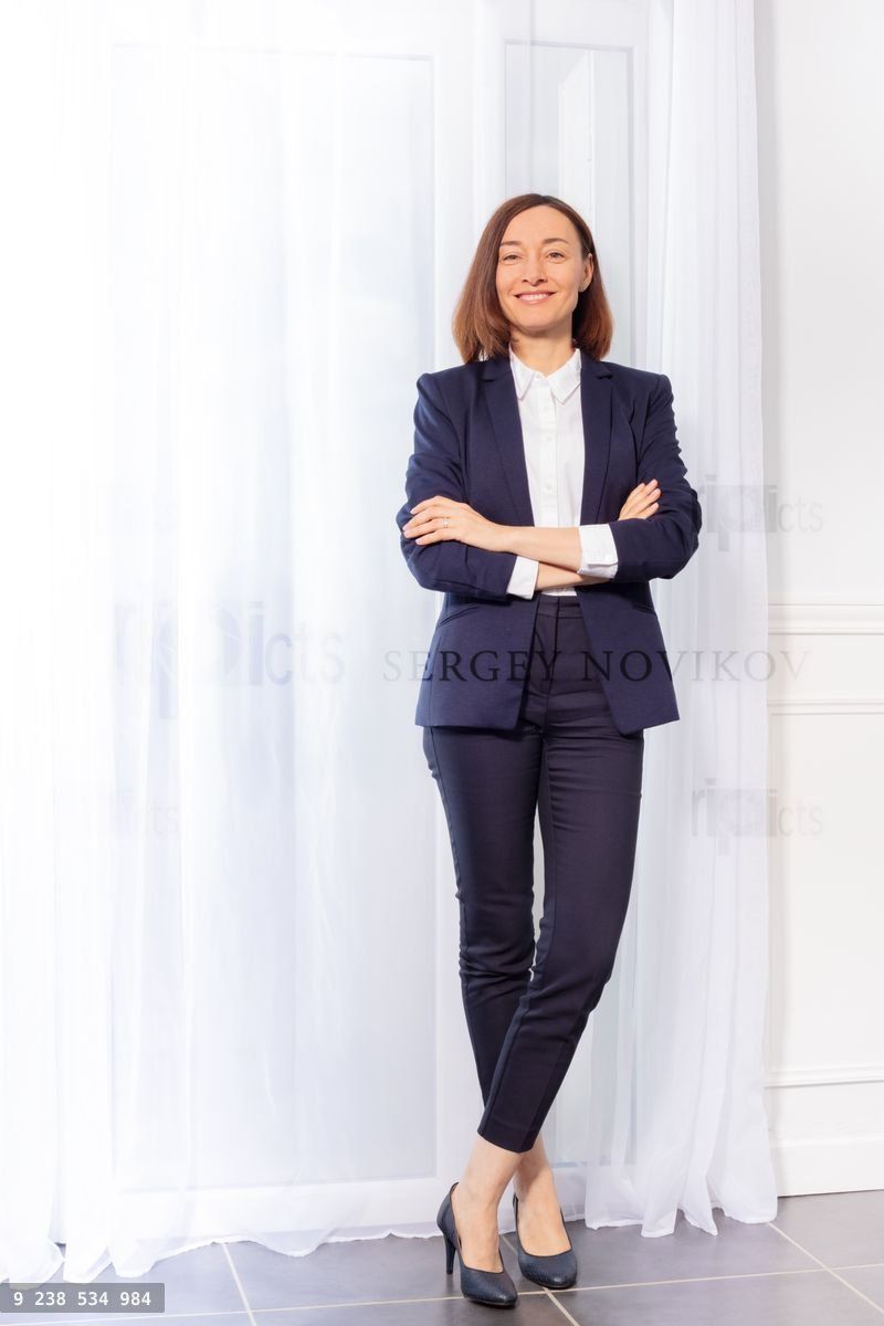 Woman in trouser suit standing with arms crossed