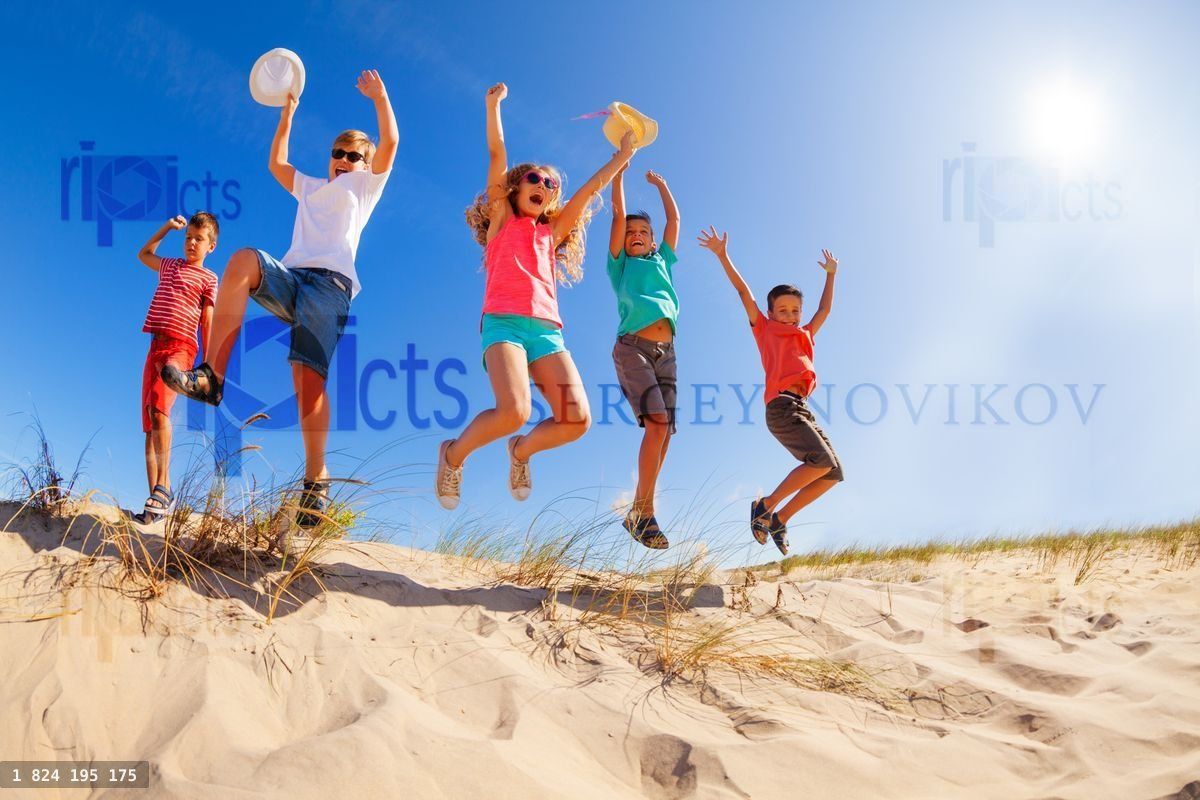 View bellow of many kids jumping from sand dune