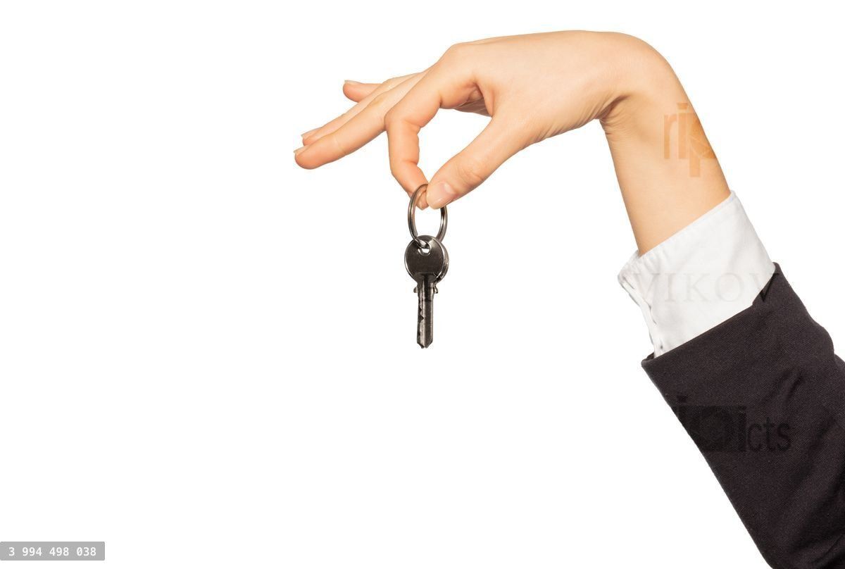 Woman's hand holding door keys with two fingers
