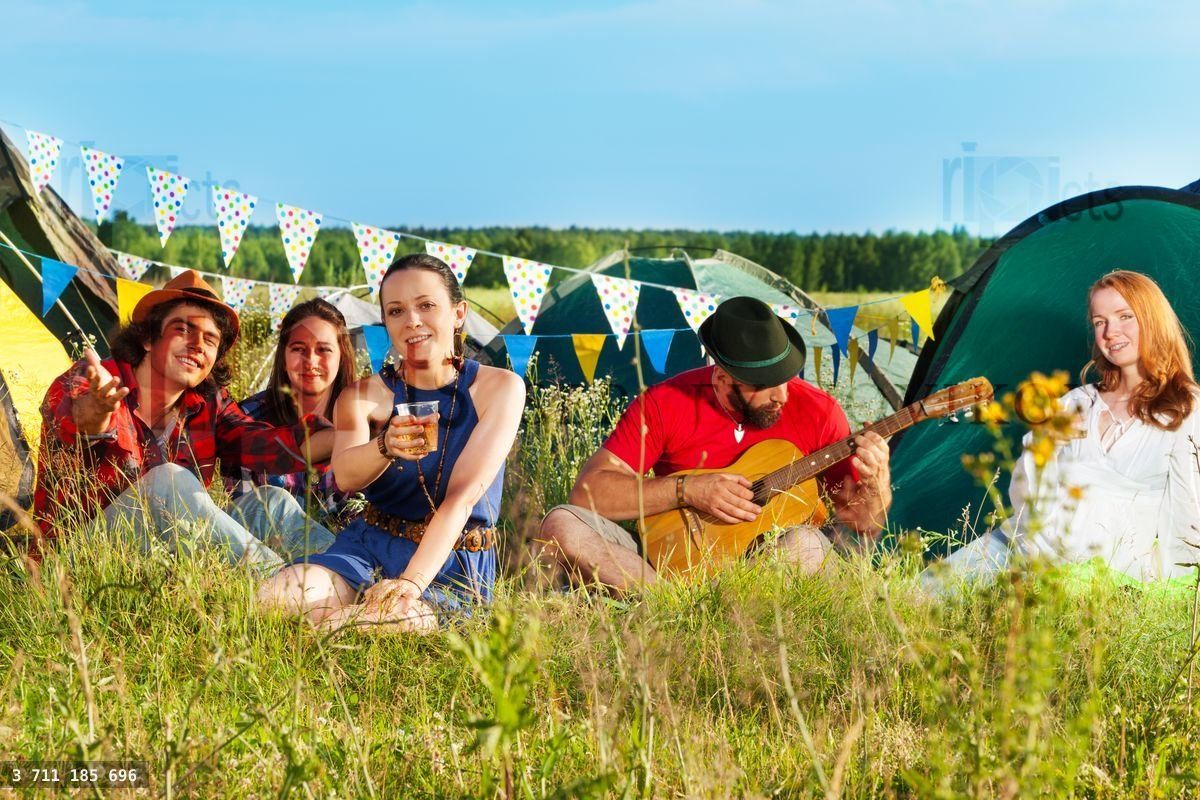 Young woman cheering at camping among her friends