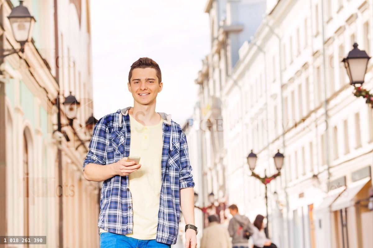 Young man with mobile phone on the street