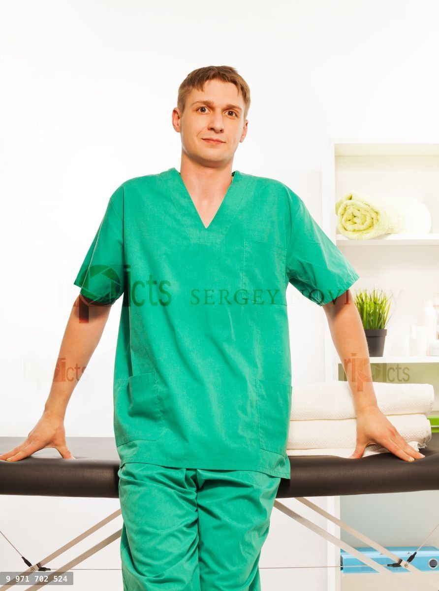 Young masseur in a uniform at the massage cabinet