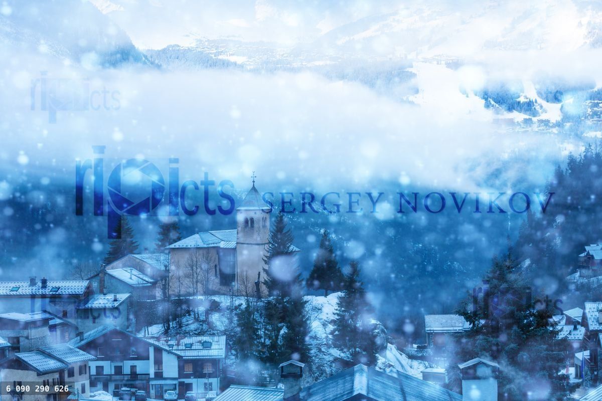 French village in snow, old church cloud covered