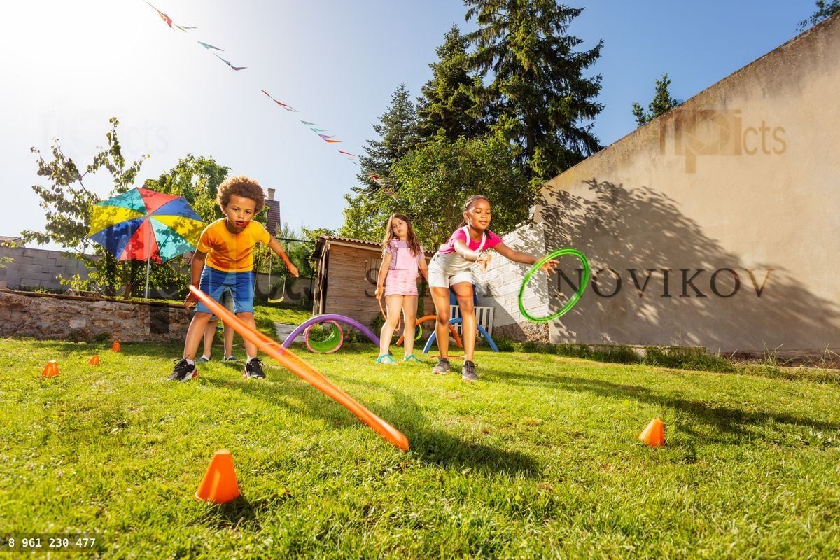 Group of kids play game throwing hula rings