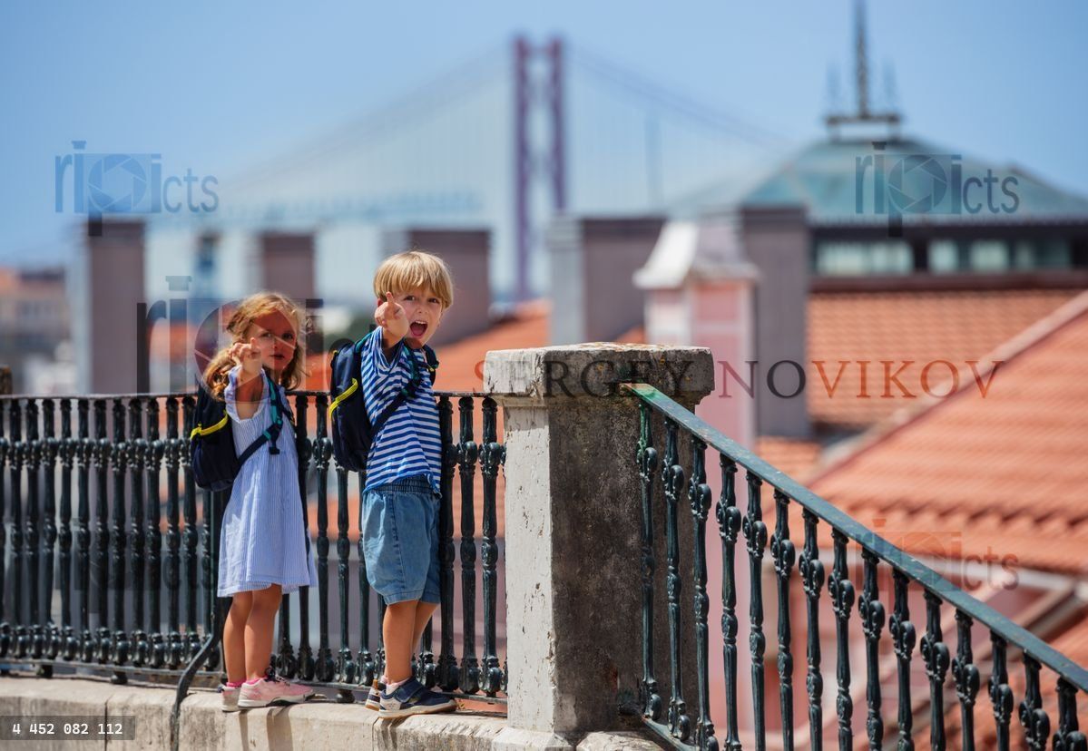 Young travelers stand at Lisbon viewpoint point with fingers