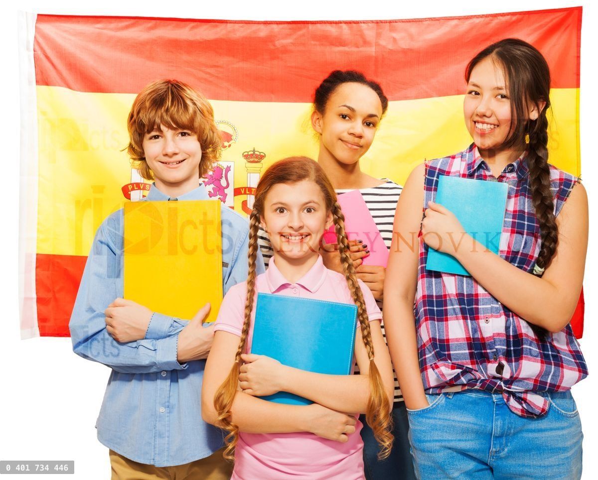 Four happy students standing with Spanish flag